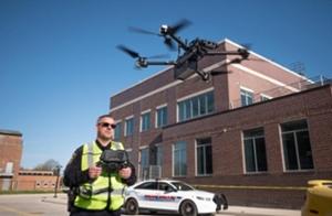 Person flying drone with police cruiser in background